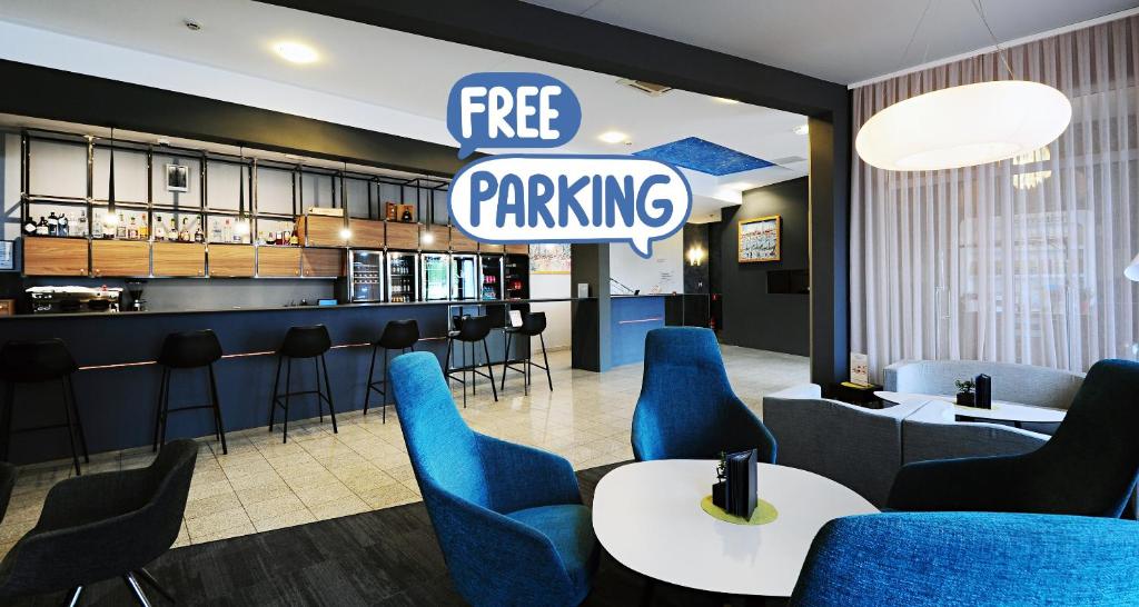 萨格勒布Best Western Airport Hotel Stella的一间设有蓝色椅子的餐厅,并有免费停车标志