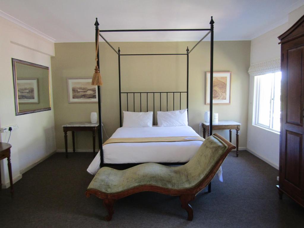 开普敦露斯汀旅馆的一间卧室配有一张大床和一把椅子