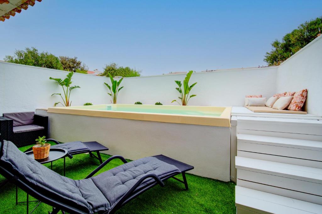 桑特柳伊斯Casa con Piscina climatizada, Jacuzzi, Billar, Aire Acondicionado的一个带热水浴缸和椅子的小后院