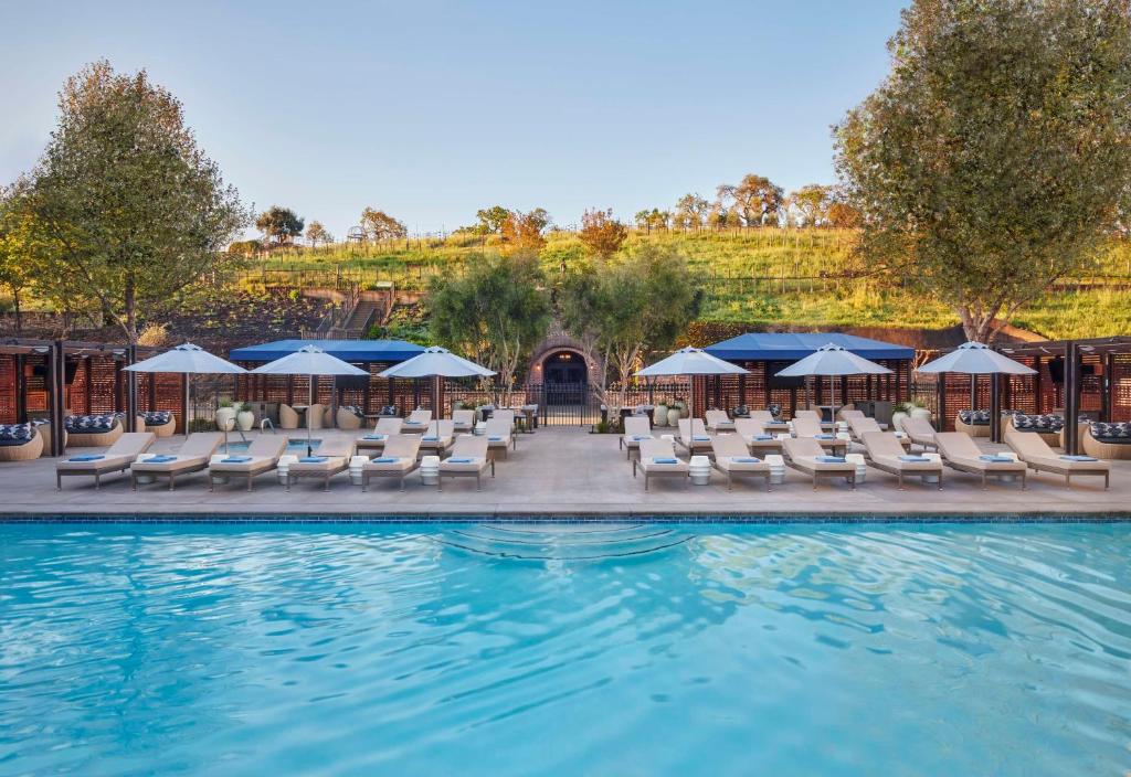纳帕梅丽泰治水疗度假酒店的一个带躺椅和遮阳伞的游泳池