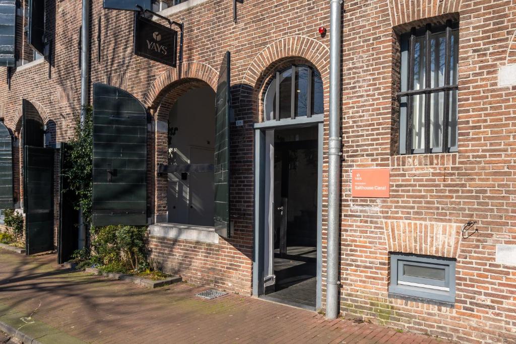 阿姆斯特丹YAYS Amsterdam Salthouse Canal by Numa的砖砌建筑的入口,设有开放式门