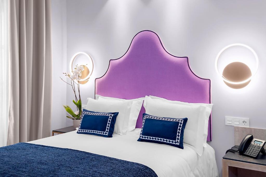 格拉纳达Hotel Casa Palacete Tablas的一间卧室配有一张大床和紫色床头板