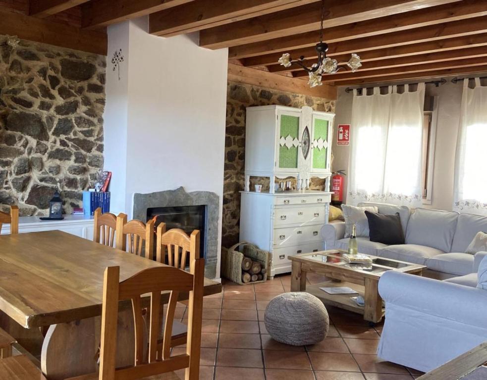 La HorcajadaCasa Rural Lucia的客厅配有桌子和壁炉