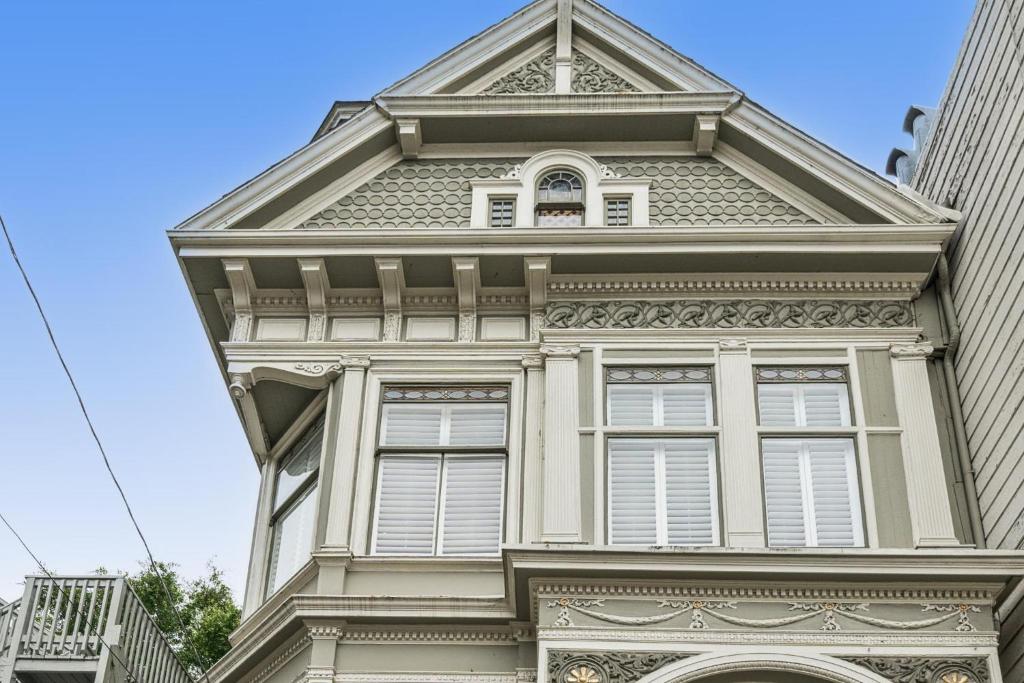 旧金山Historic & Charming Victorian Home Sleeps 11的一座高大的建筑,有白色的窗户和塔楼