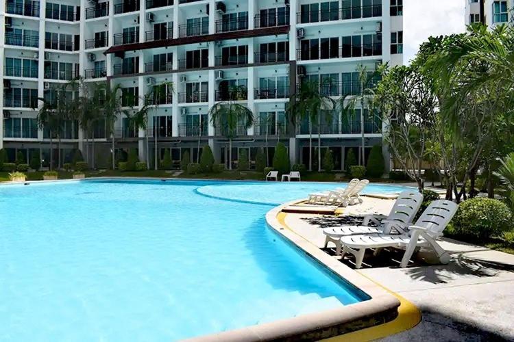 Ban Bo KhaemAD Resort Cha-am/Huahin by room951的一座带躺椅的游泳池以及一座大型建筑