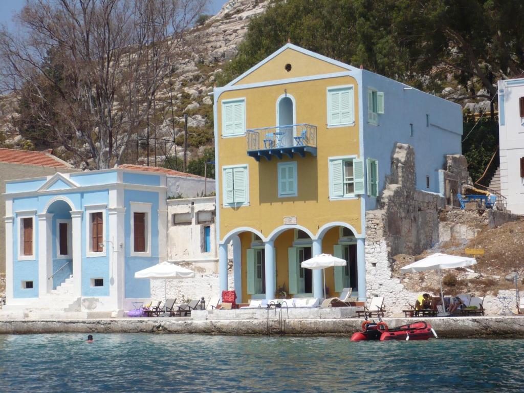 迈伊斯蒂Mediterraneo Hotel的水边的黄色和蓝色建筑