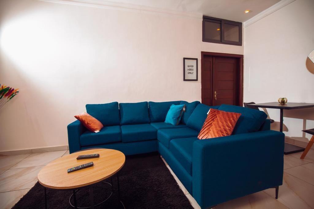 GodomèAppartement meublé type T2的客厅配有一张蓝色的沙发,配有一张桌子