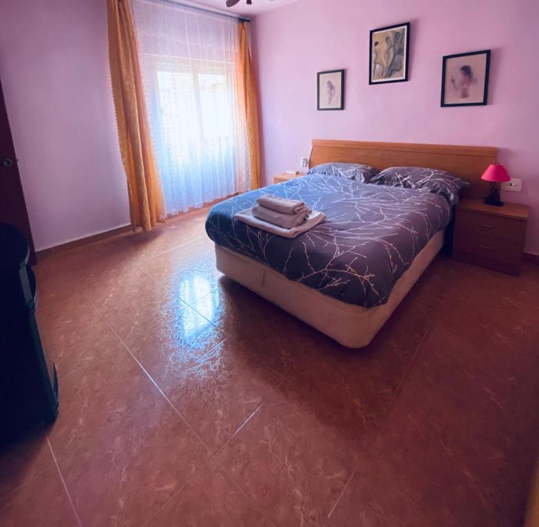 AlgaidaCompleta y Amplia Habitación a 10 minutos de la playa Casa Compartida的一间卧室配有一张带蓝色棉被的床