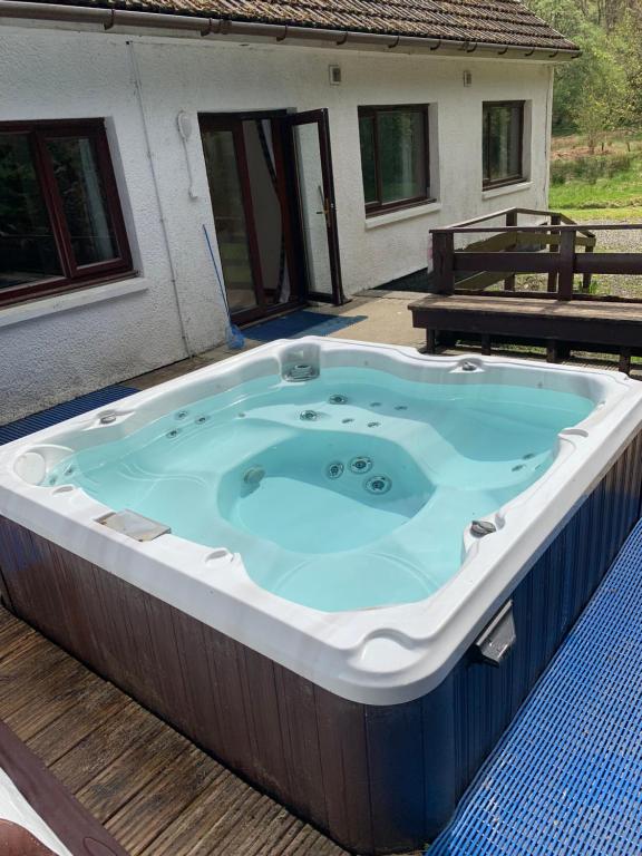 史宾桥Captivating 5-Bed Cottage with private hot tub的甲板上的按摩浴缸