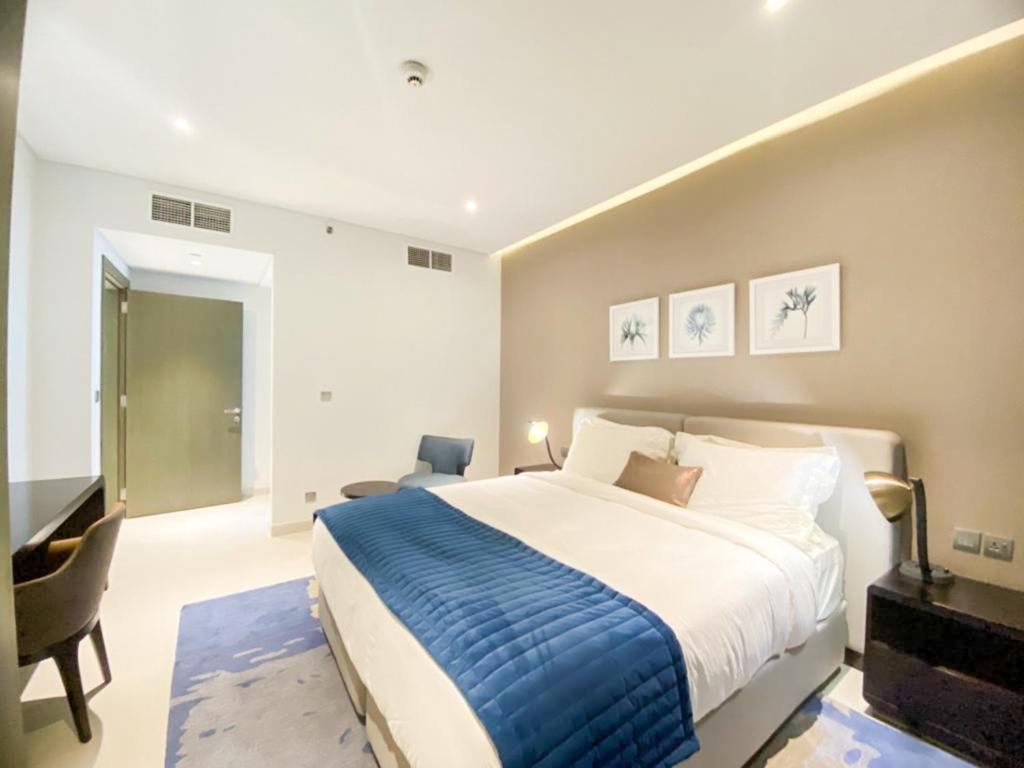 迪拜Comfy 1BR in Damac Maison Prive by Huaxia Homes的一间卧室配有一张大床和一张书桌