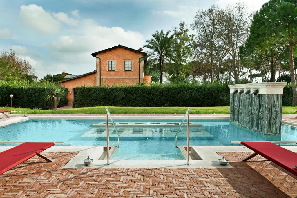菲乌米奇诺QC泰尔梅罗玛SPA度假酒店的一个带两把红色椅子的游泳池