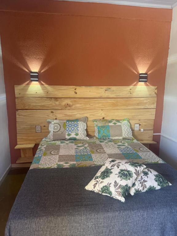 卡瓦坎特Pousada Recanto do Tucano的一间卧室配有一张带木制床头板和枕头的床。