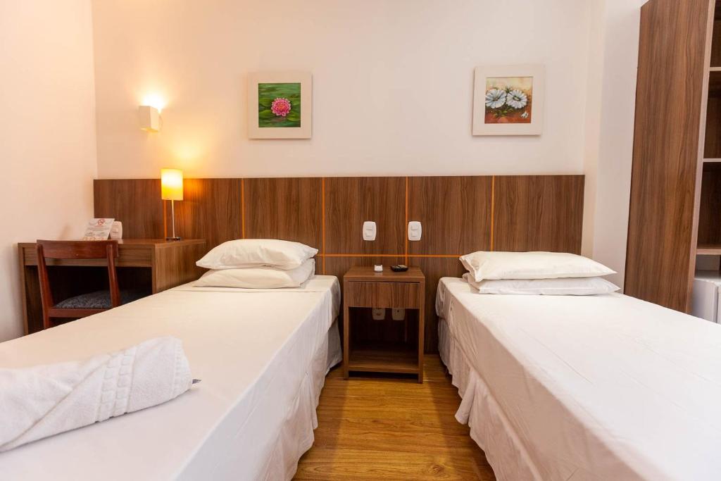 里约热内卢Rede Andrade Canada的客房设有两张床和一张书桌。