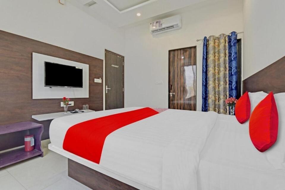乌代浦Hotel ANGAN的卧室配有带红色枕头的大型白色床