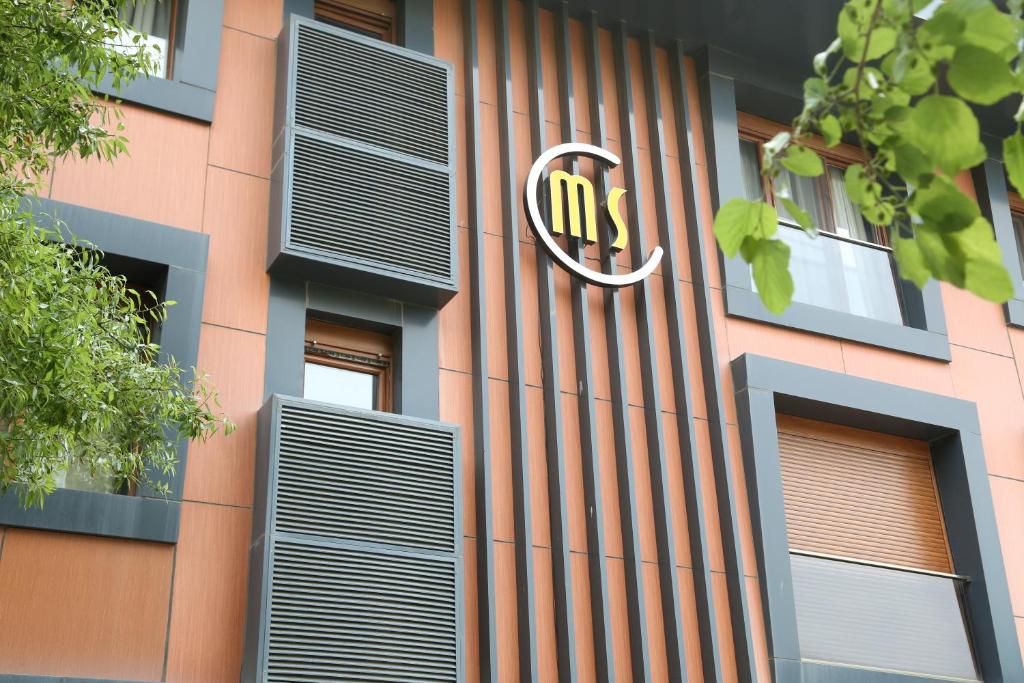 埃杰阿巴德Maidos suites的建筑的侧面带有nmc标志