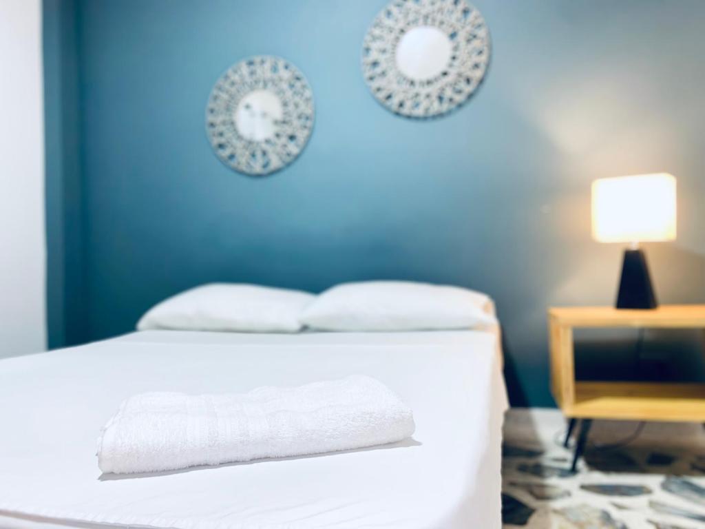 麦德林Casa compartida ''Central Hostel''的蓝色的卧室配有一张床和一张带台灯的桌子
