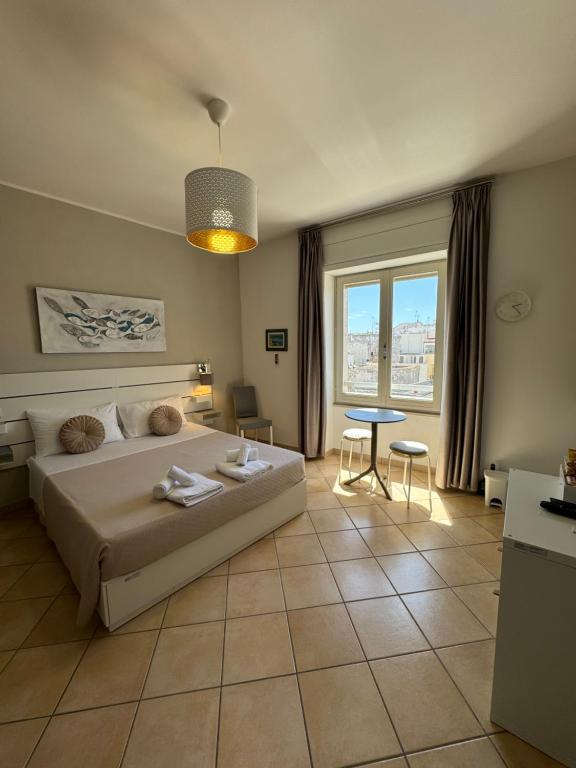 奥特朗托San Pietro Otranto的一间卧室配有一张床、一张桌子和一个窗户。