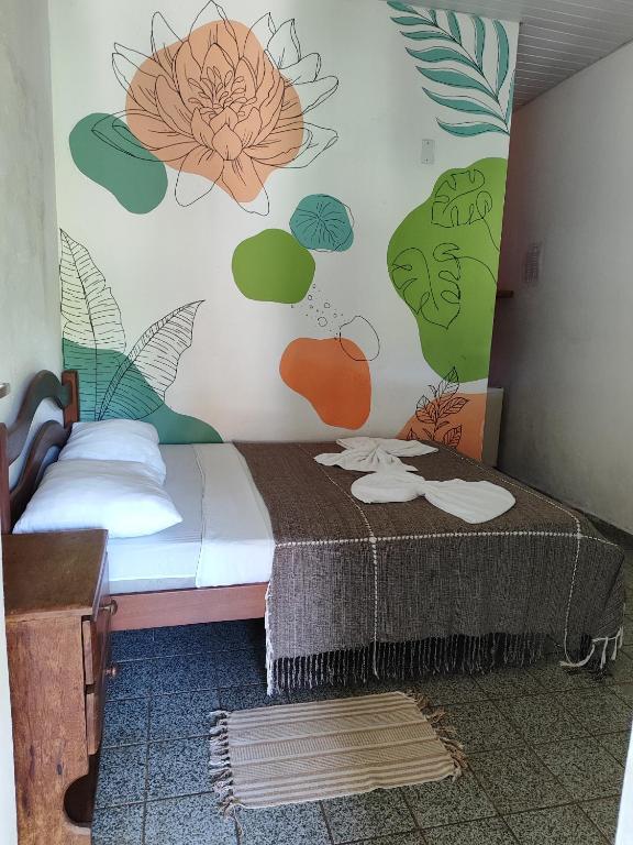 皮帕Pousada Carambola的卧室配有一张挂着花壁画的床。