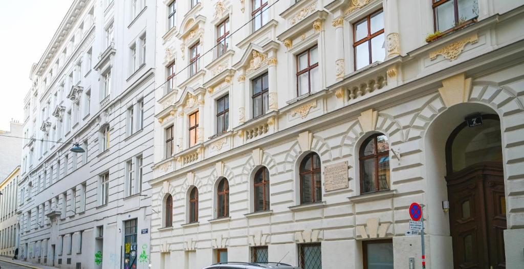 维也纳Exclusive Suite Museumsquartier的街道上有许多窗户的大型白色建筑