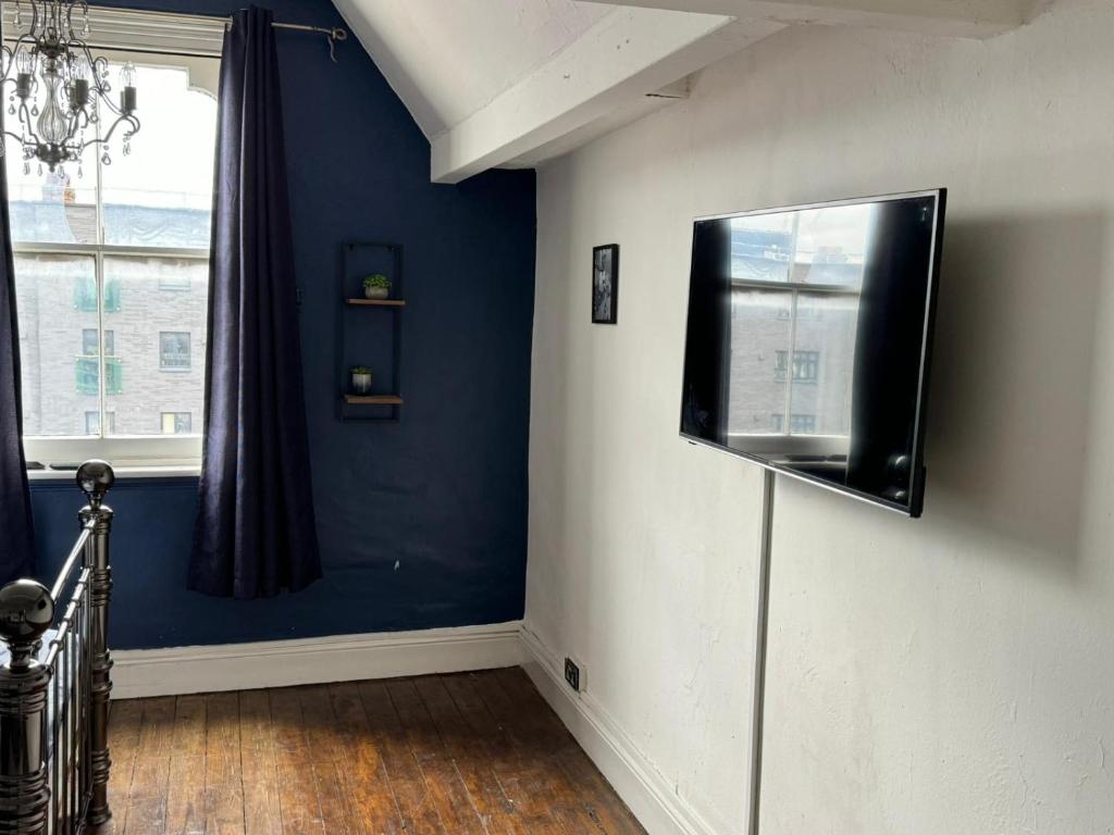 伯明翰Premium Dighbeth的一间设有蓝色墙壁和平面电视的客房