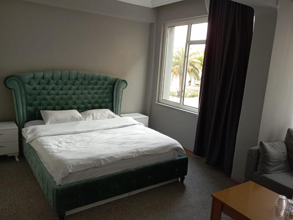 萨姆松Samsun Otel Vidinli的一间卧室配有一张带绿色床头板的床和窗户