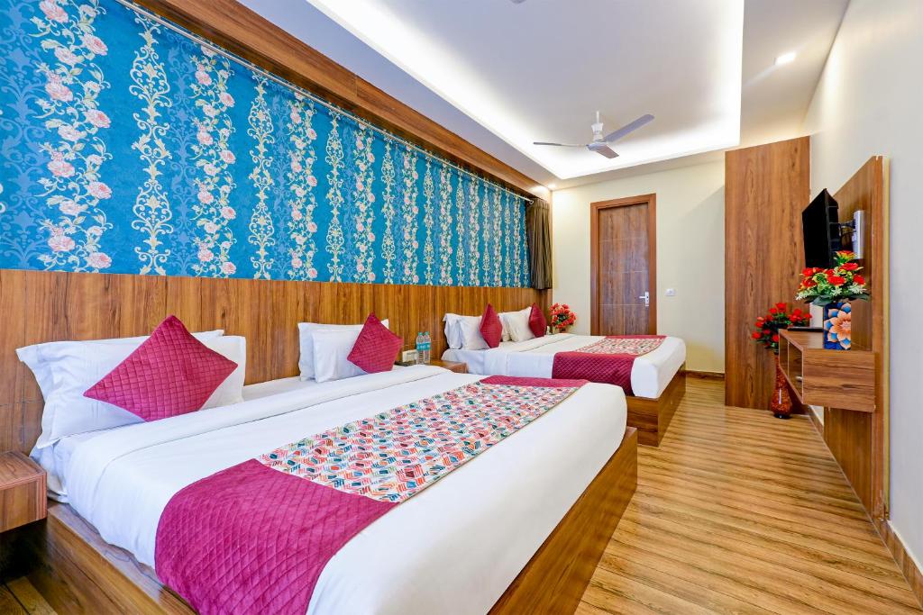 新德里Wood Rose Hotel Near Delhi Airport的一间酒店客房,设有两张床和电视