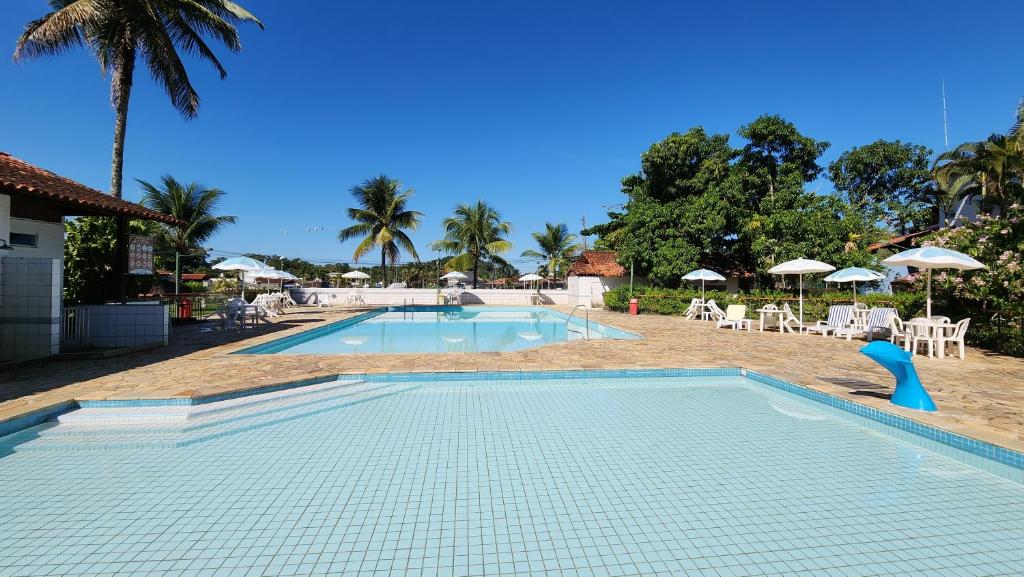 安格拉杜斯雷斯Apartamentos, Praias, Piscinas, Luxo - Angra Temporada的一个带椅子和遮阳伞的度假村游泳池