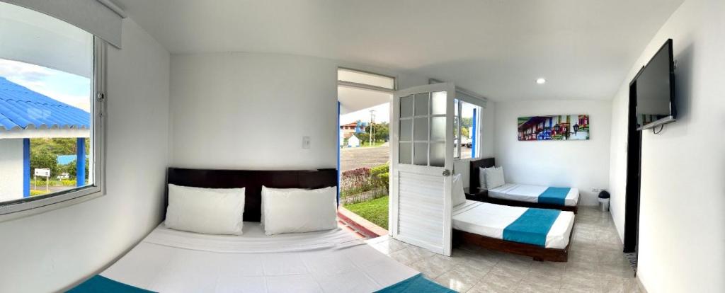 佩雷拉Hotel Villa Mónaco的一间卧室设有两张床和窗户。