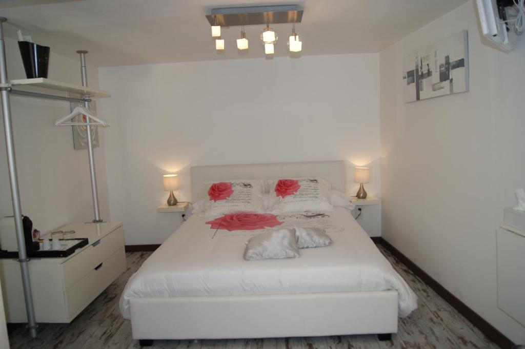 卡斯泰尔诺勒莱B&B Villa Castelnau Montpellier的一间卧室配有一张白色的床铺,上面有红玫瑰