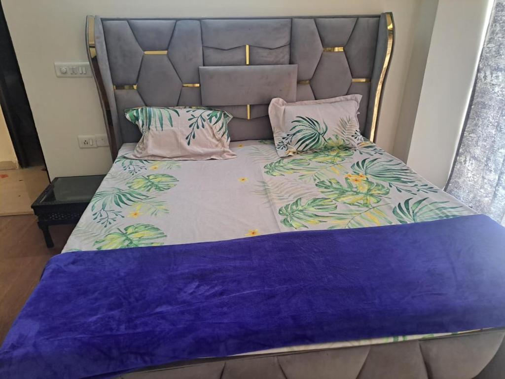 加济阿巴德2Bhk fully furnished flat.的一张带床头板的床铺,配有紫色床单和枕头