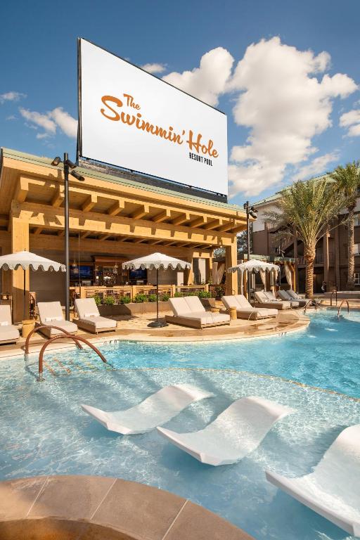 拉斯维加斯Silverton Casino Lodge的一个带椅子和标志的度假村的游泳池