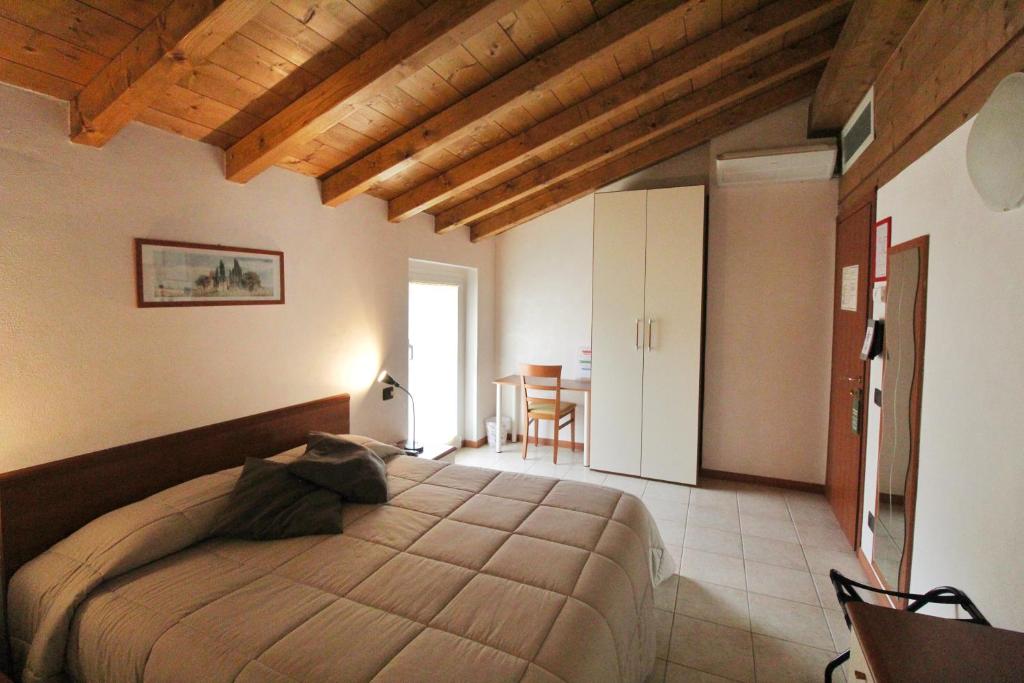 圣佩莱格里诺温泉阿伏伽德罗酒店的一间卧室配有一张大床和一张桌子