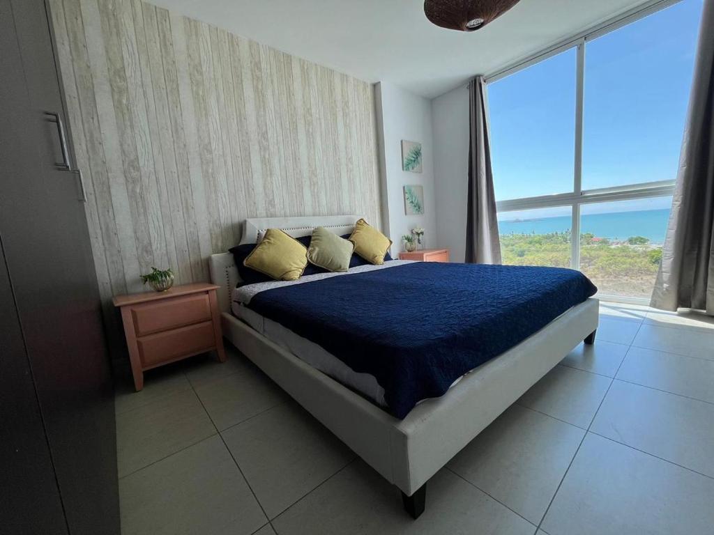 普拉亚布兰卡Playa Blanca Beach Rentals的一间卧室设有一张床和一个大窗户