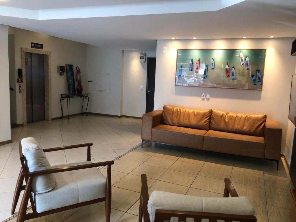 伊达贾伊Hotel Graju Itajaí的客厅配有沙发和椅子