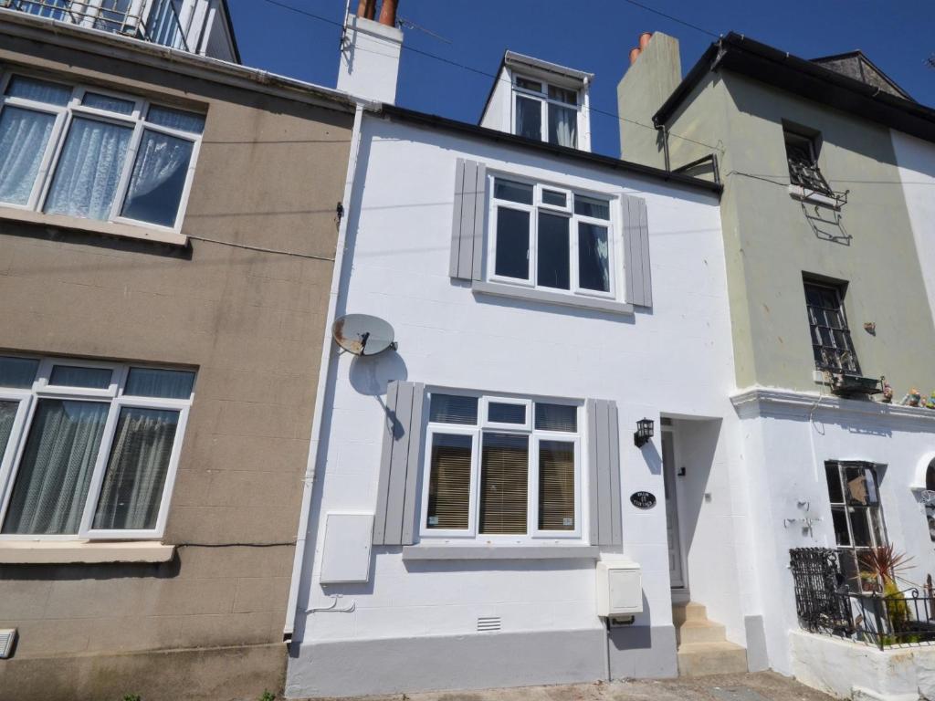 布里克瑟姆3 bed property in Brixham 56862的一栋大楼旁的白色房子