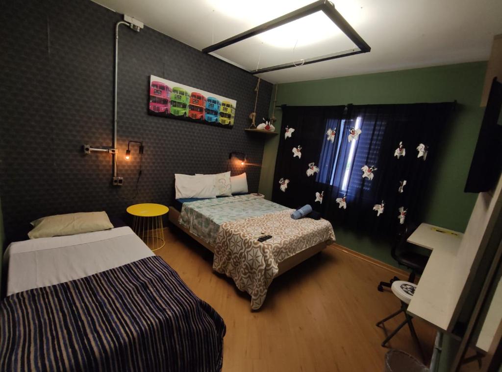 瓜鲁柳斯Pousada Casa dos Gattos - Próx ao Aeroporto Guarulhos的一间小卧室,配有两张床和窗户