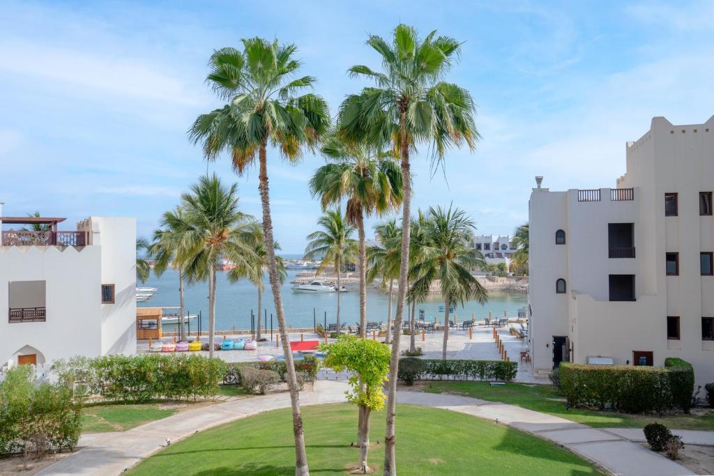 塞拉莱Wateera Hawana Salalah的享有海滩和棕榈树的景色,位于大楼前