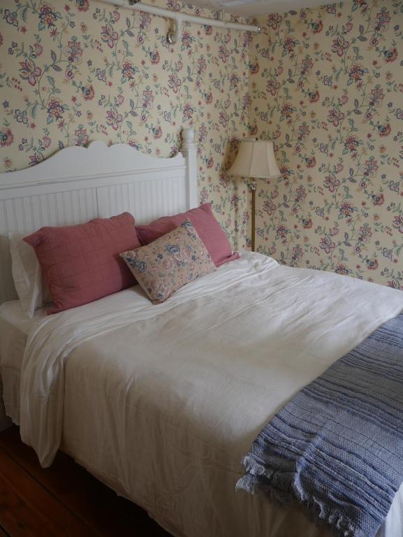Mays LandingThe Inn at Sugar Hill的卧室配有粉红色枕头,卧室配有花卉壁纸