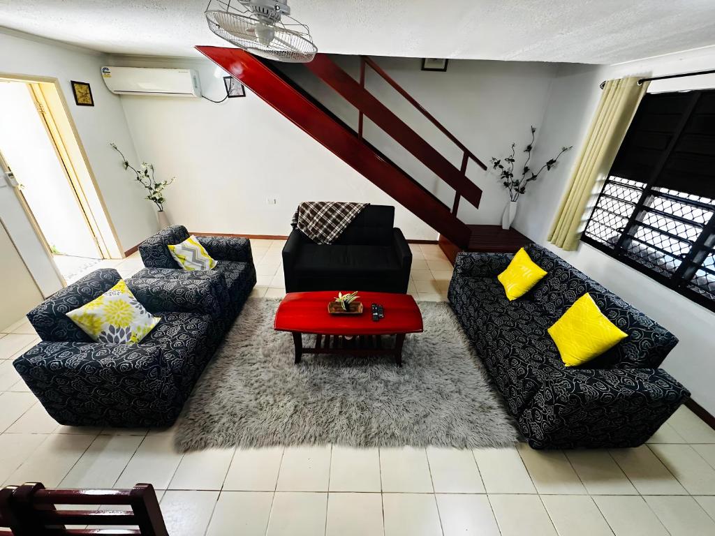 南迪Cozy, Comfortable, Family Home.的客厅配有两张沙发和一张红色桌子