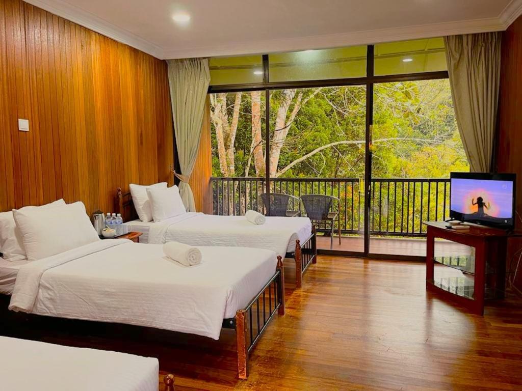 彭亨LiLLA Hilltop Retreats Janda Baik formerly known as Serene Resort的酒店客房设有三张床和阳台
