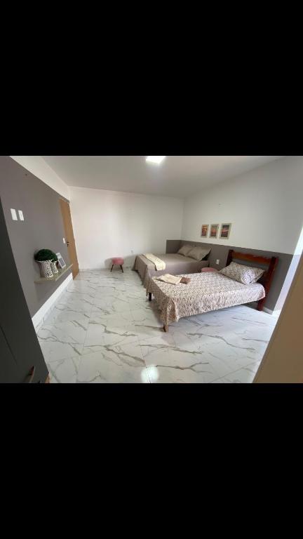 维索萨-杜塞阿拉Viçosa Flat的一间带两张床和一张沙发的客厅