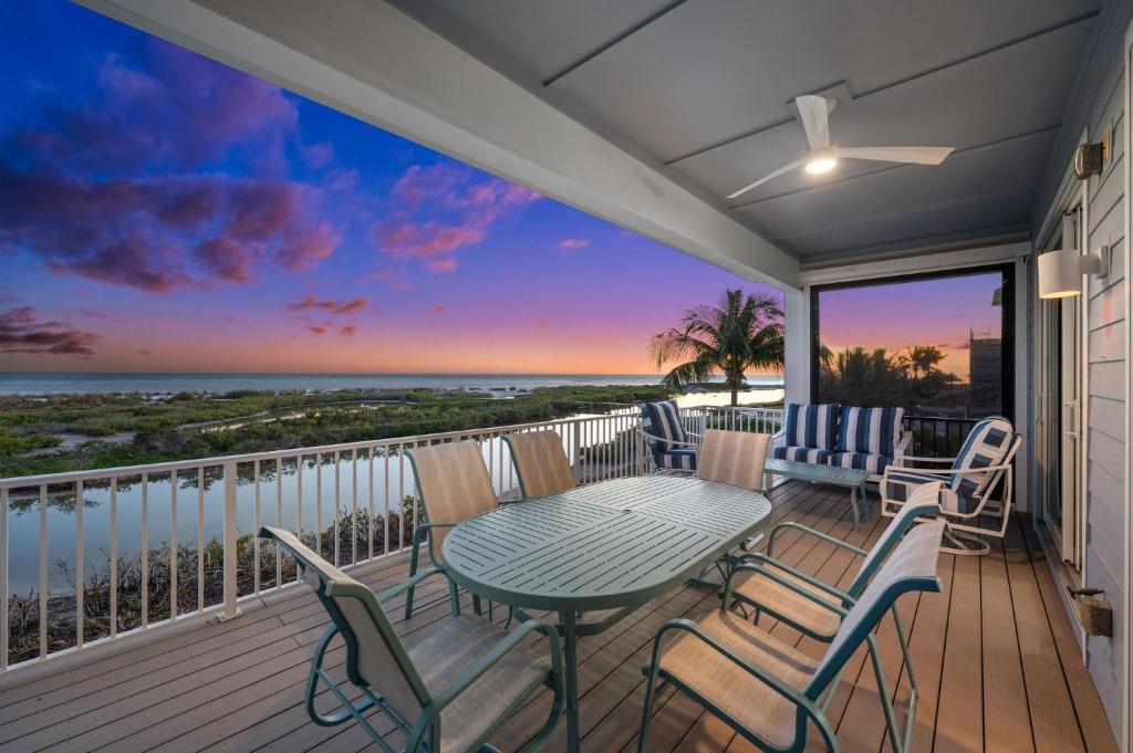 迈尔斯堡海滩Papa's Boat House - 8214 Estero Blvd home的阳台配有桌椅,享有海景。