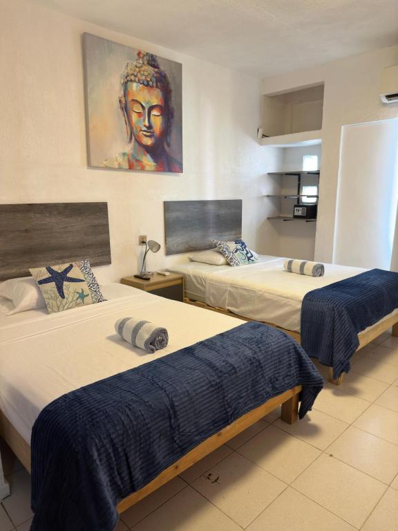 韦拉克鲁斯Suites Brisa Marina - Playa Regatas y Malecón的酒店客房设有两张床,墙上挂有绘画作品