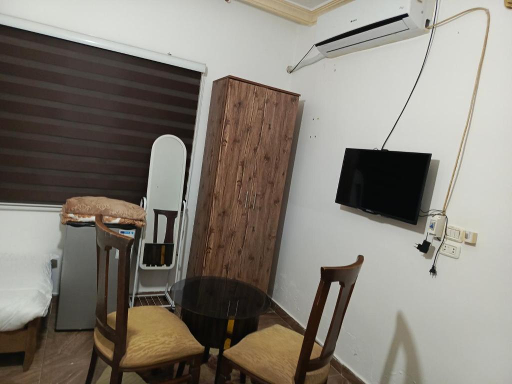 杰拉什Jerash ruins hotel的配有桌椅和电视的客房