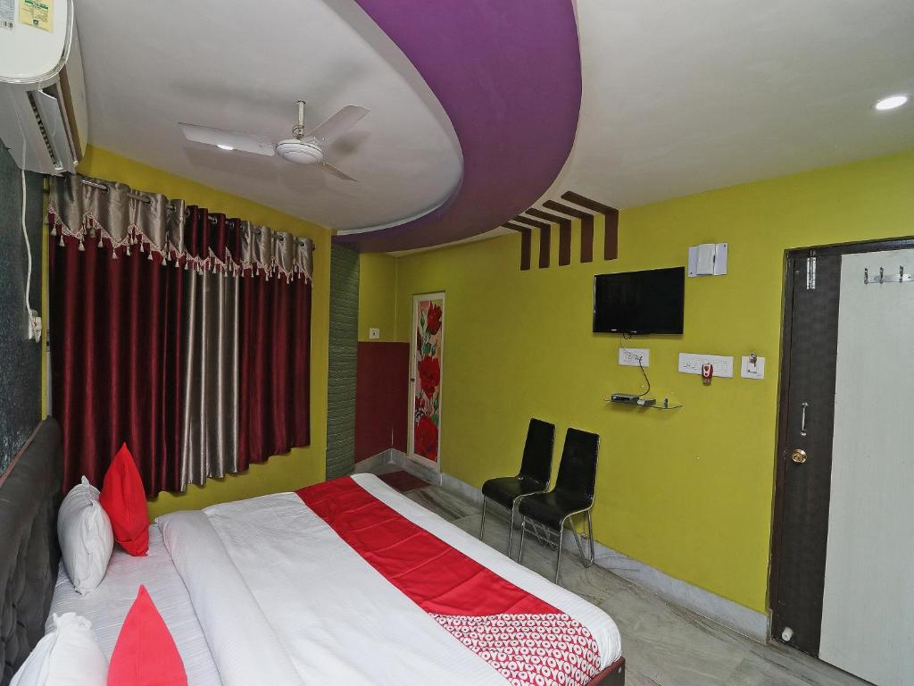 GauripurOYO Hotel Jagannath International Near Kolkata Airport的卧室配有一张床,墙上配有电视。