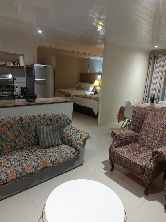 比勒陀利亚紫橄榄宾馆的一间带两张沙发的客厅和一间卧室