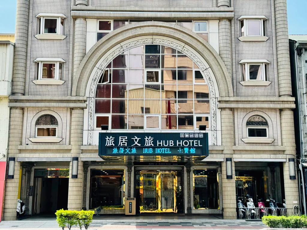高雄Hub Hotel Kaohsiung Cisian Branch的前面有标志的大建筑