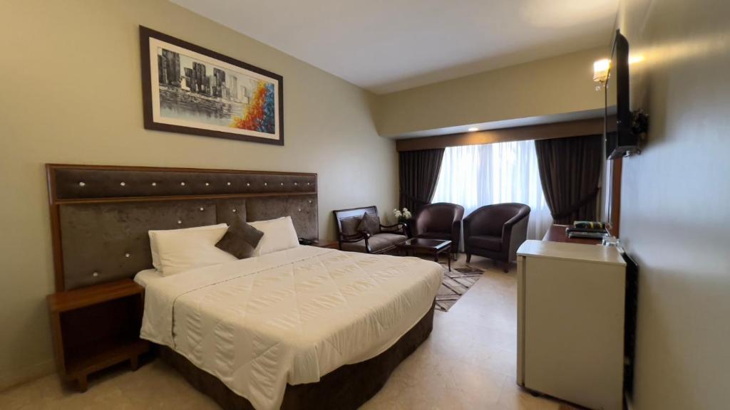 卡拉奇Faran Hotel的酒店客房,配有床和椅子