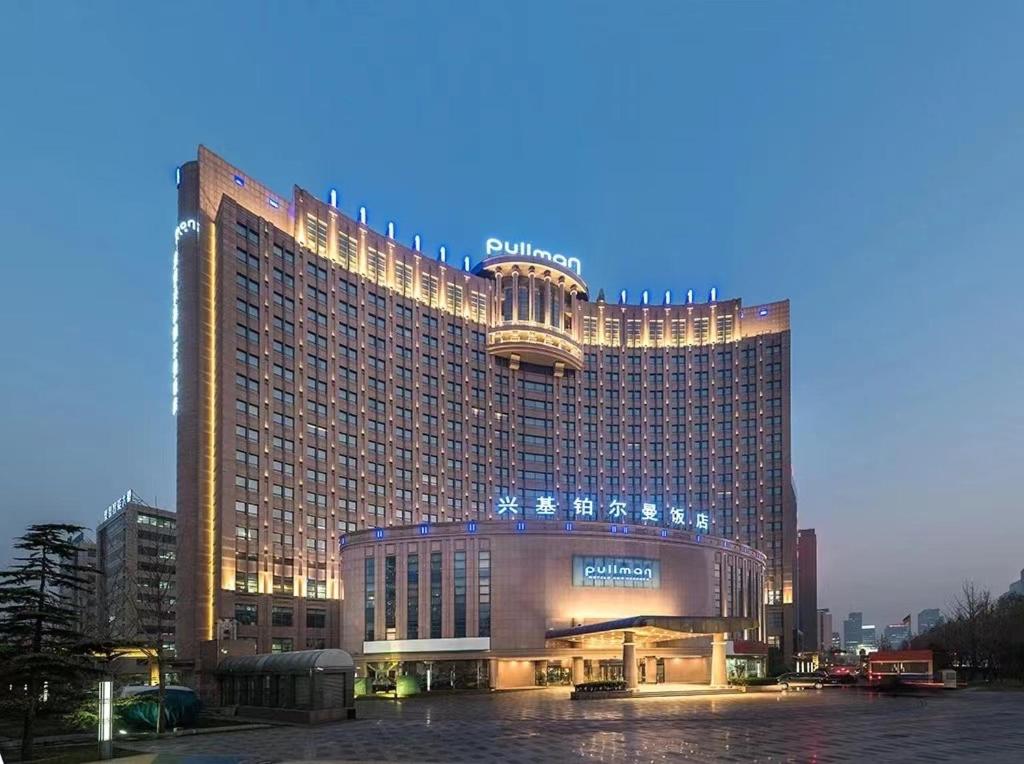 大兴北京兴基铂尔曼饭店的一座大型酒店大楼,灯火通明