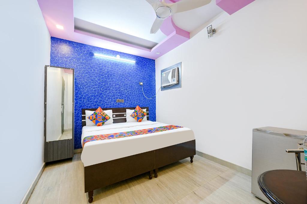 加济阿巴德FabHotel Capital Inn的一间卧室配有一张蓝色墙壁的床